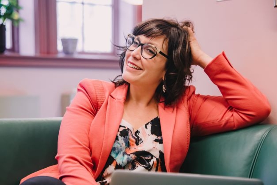 Chantal Borst, smiling, sits on a couch